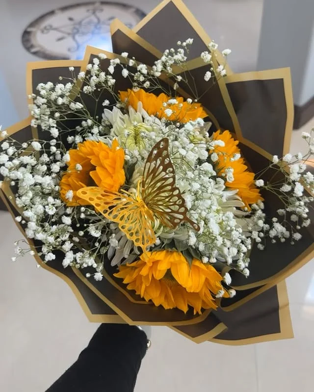 Vibrant sunflower bouquet with a golden butterfly detail