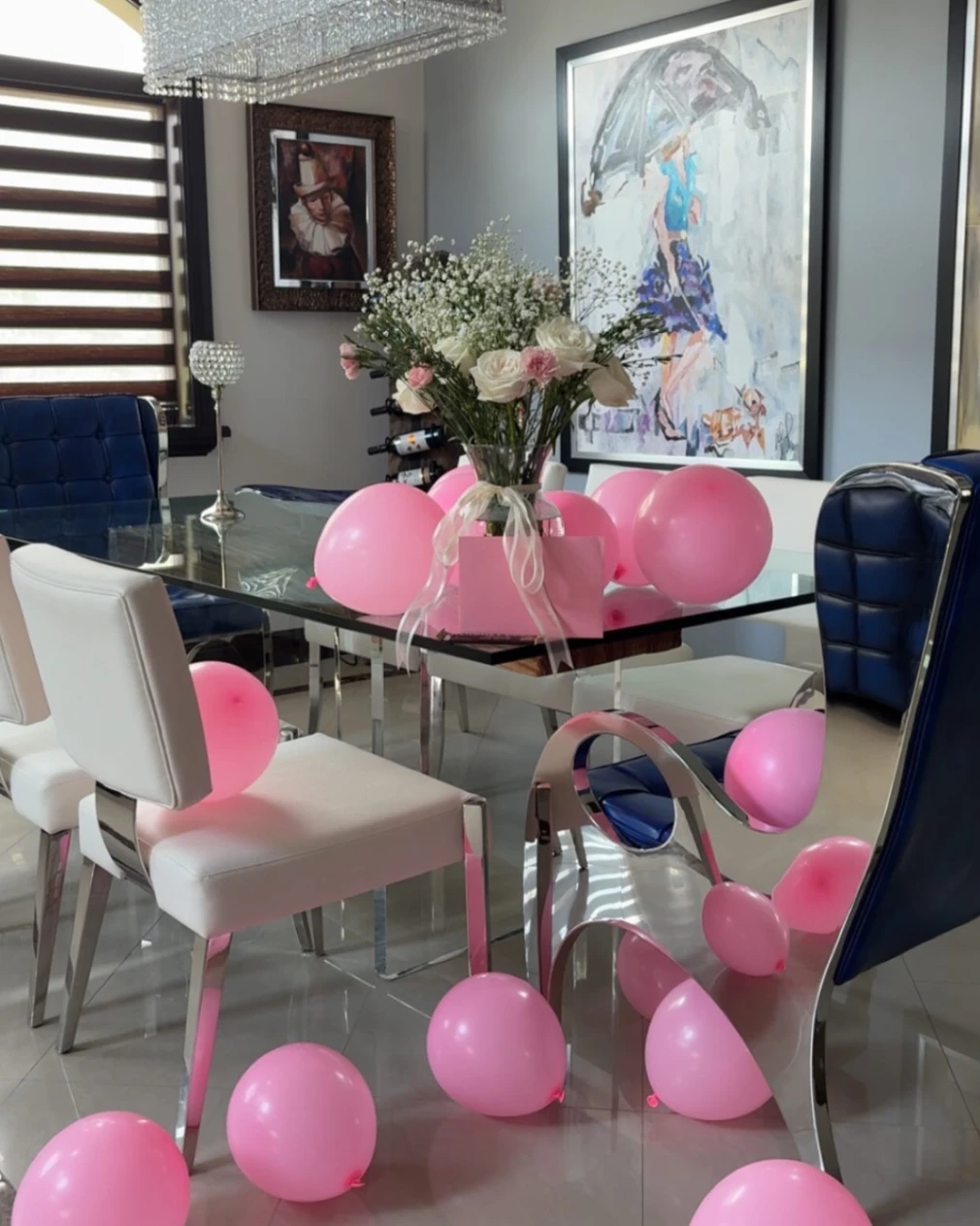 Elegant dining table set with pink balloons and a fresh flower centerpiece